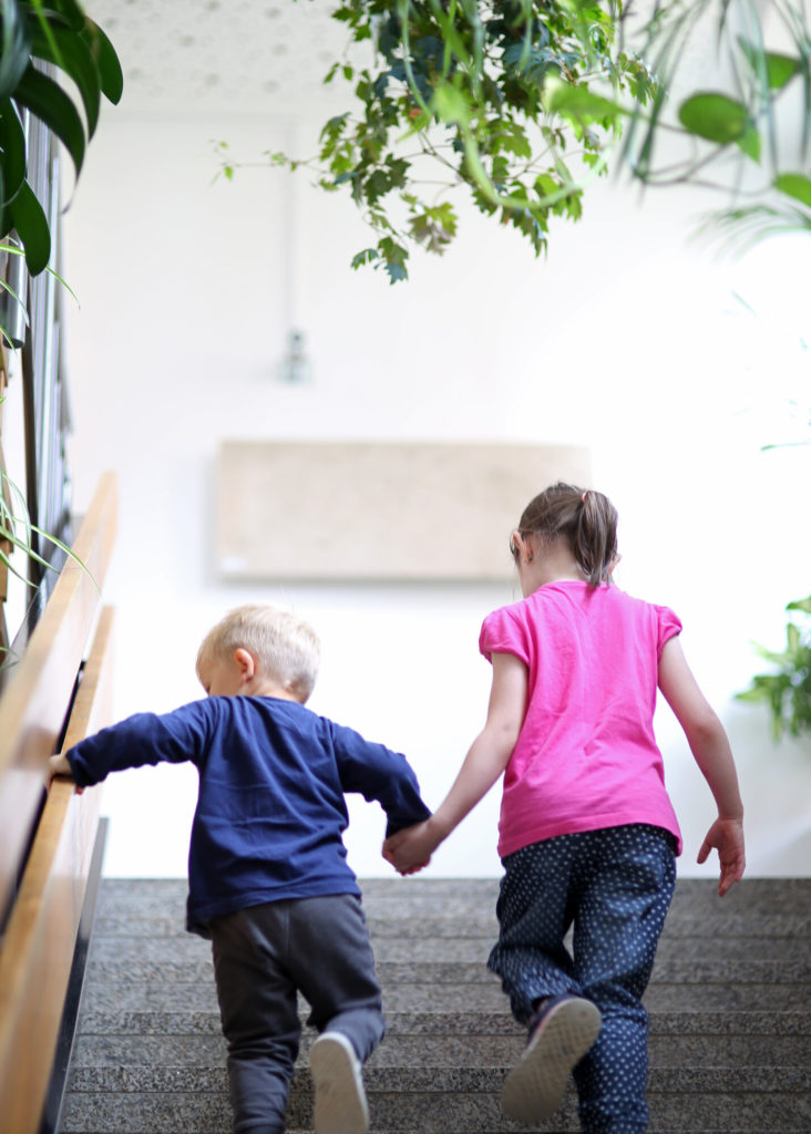 zwei Kinder gehen eine Treppe hinauf