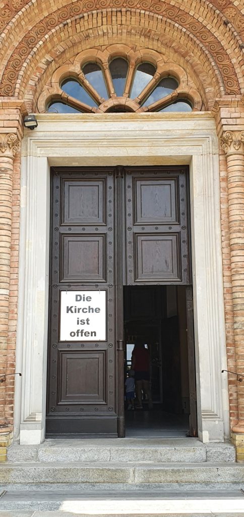 Offene Kirchtüren und die Inschrift: Die Kirche ist geöffnet.