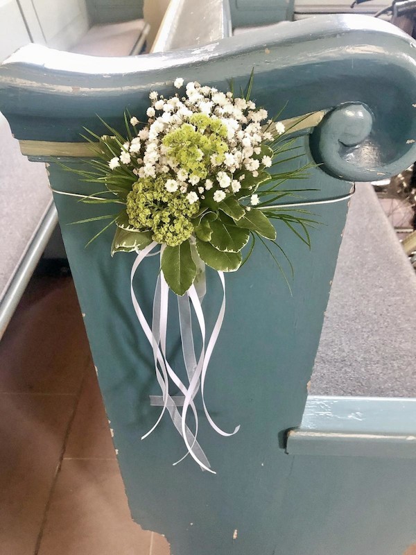 Blumen als Accessoire auf einer Kirchenbank
